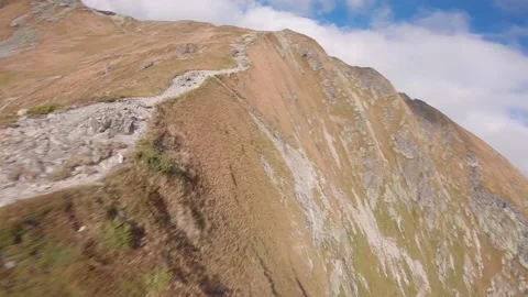 FPV drone flying really close to ground in high rocky mountains Stock Footage 169280619