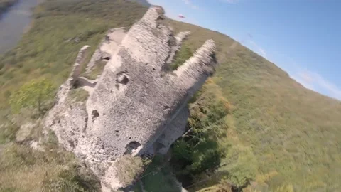 FPV drone flying really close and crazy around ancient castle in green mountains Stock Footage 169280647