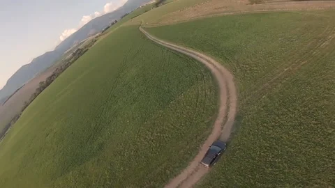 FPV drone flying on summer field around drone pilot and a car Stock Footage 169280483