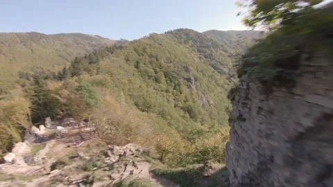 FPV drone flying through a hole in an ancient castle in high green forest Stock Footage 169280657