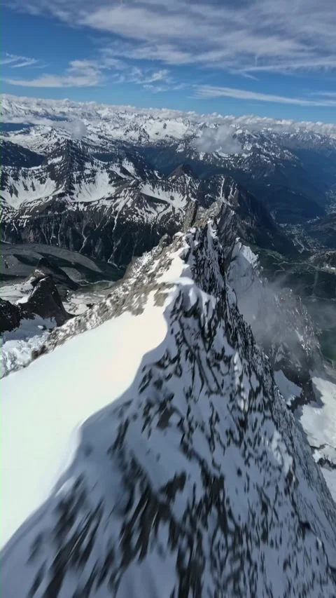 Fpv drone flyover snowy mountain ridge steep alpine peak valley Stock Footage 340976374