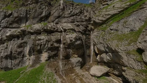 FPV Drone Following Mountain Stream Through Alpine Valley Stock Footage 312818731