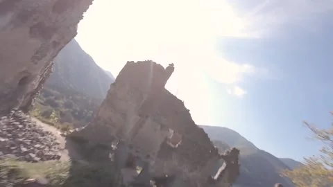 FPV drone freestyling around an ancient castle in high green forest Stock Footage 169280653