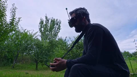 FPV drone man pilot sitting side view 4K video outdoor blue sky 스톡 동영상 280365321