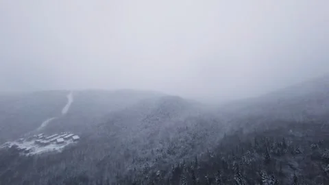 Fpv drone passing above snowy houses in mountain village Stock Footage 321251729