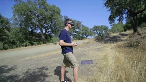 FPV Drone Pilot Actively Controlling a Drone in a Beautiful Outdoor Environment Stock Footage 291136124