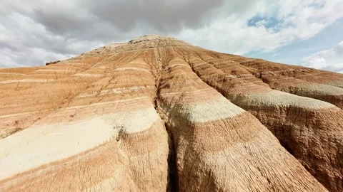 FPV drone pullback descending over colorful Aktau Mountains in Altyn Emel. Video stock 334612687