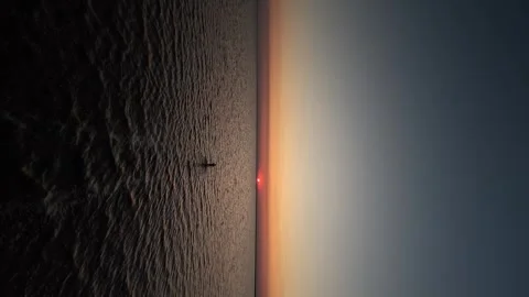 The fpv drone quickly flies after a person walking along a shallow salt lake Stock Footage 256224432