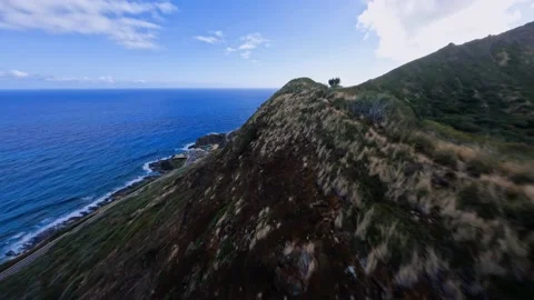 FPV drone shot flying parallel to a crater ridge on the coast of Hawaii, Stock Footage 210054408