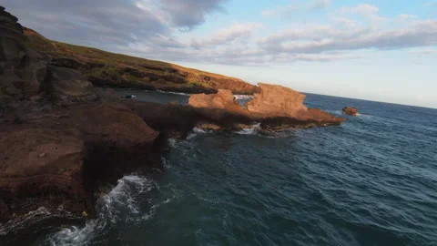 FPV drone shot flying through jagged rocks and beach, Hawaiian coast, Stock Footage 153483713