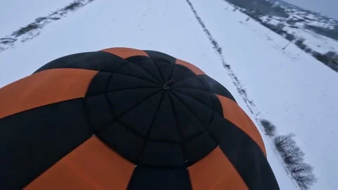 FPV Drone Shot of Hot Air Balloon Flying High Above White Winter Stock Footage 195101835