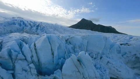 FPV drone shot over cracked glacier ice with volcanic soot, in Stock Footage 218345005