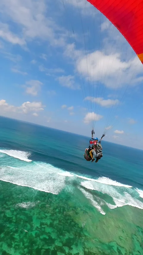 FPV drone shot of paragliders gliding over ocean and cliffs in Bali, Indonesia 動画素材 306518949