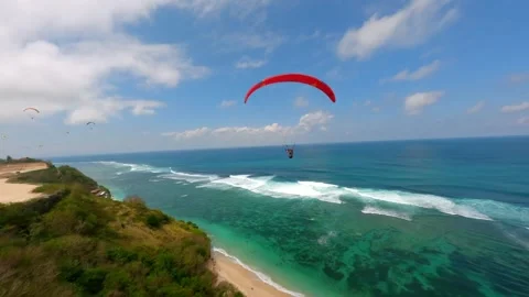 FPV drone shot of paragliders gliding over ocean and cliffs in Bali, Indonesia Stock Footage 306520124