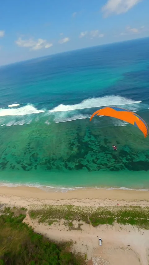 FPV drone shot of paragliding above cliffs of Pandawa Beach in Bali, Indonesia Видео 340169864