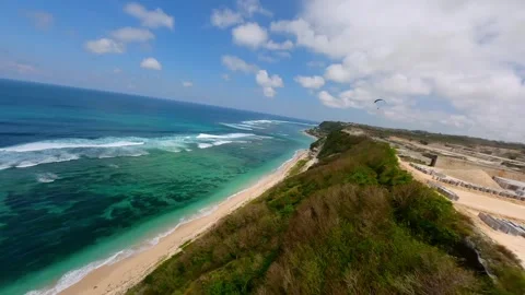 FPV drone shot of paragliding above cliffs of Pandawa Beach in Bali, Indonesia 動画素材 340189463