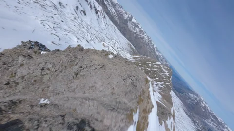 FPV Drone Soaring Over Snowy Cliffs and Dramatic Peaks at Pic de la Mina, France Stock Footage 295012763