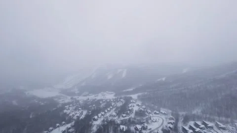 Fpv drone soaring over snowy mountain spine in snowfall Stock Footage 321251528