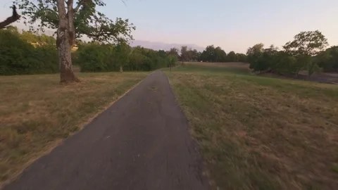 FPV Drone Speeding Low Over a Path at Sunset, POV Aerial Stock Footage 341236578