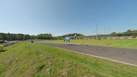 FPV Drone Tracking Helicopter Takeoff During Motorsport Event Vidéo 334876492