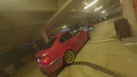 FPV Drone Underground Drift Battle: Black-Red BMW vs Red BMW with Gold Wheels Stock Footage 327029680
