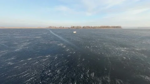 FPV Drone view. Airboat skating on frozen river at sunset near embankment. Video stock 147089286