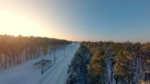 FPV drone view. Fast flight over the railway in the winter forest at sunset Vídeos de archivo 147996179