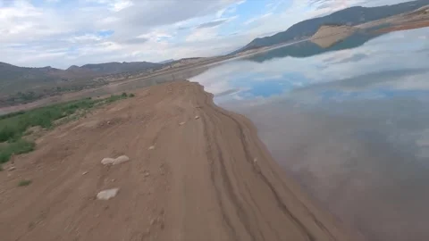 FPV Drone View Flying Fast Over a Sandy Shore Near a Lake in Andalusia, Spain Stock Footage 346568018