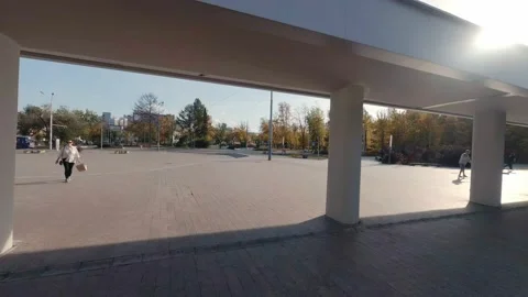 FPV drone view of Guys are skating on the square next to the modern building Stock Footage 216934955