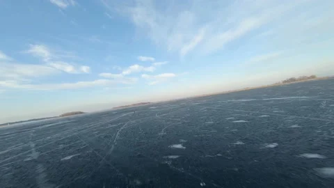 FPV drone view of low and fast flight over the frozen river at sunset Video stock 147089335