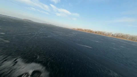 FPV drone view of low and fast flight over the frozen river at sunset Vídeos de archivo 147089482