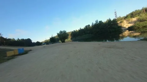 FPV drone view quickly flies over the beach and calm water river at dawn Video stock 169504253