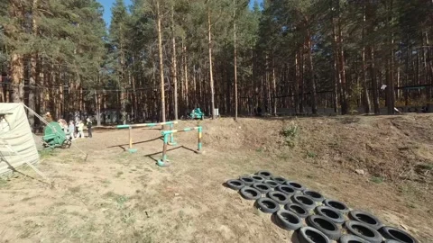 FPV drone view of zipline track with girl in the forest near an obstacle course Stock Footage 220422019