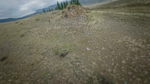 FPV drone will fly low above the ground near a young girl. The girl goes hiking Stock Footage 278367985