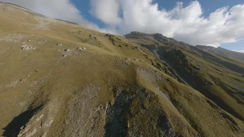 FPV flight along barren alpine ridge toward cloudy peak Stock Footage 336870321