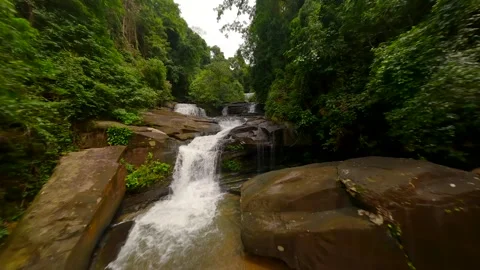 FPV flight over cascading river and beautiful waterfall in lush jungle, Thailand Stock Footage 279877048