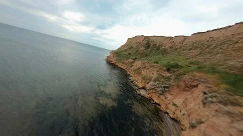 FPV flight over a coastal cliff at cloudy day Video stock 168883992