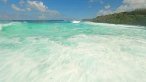 FPV flight over crystal clear turquoise water and splashing ocean waves in Bali Stockbeeldmateriaal 288192988