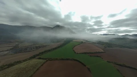 FPV flight over farmland beneath dramatic clouds Stock Footage 346000897