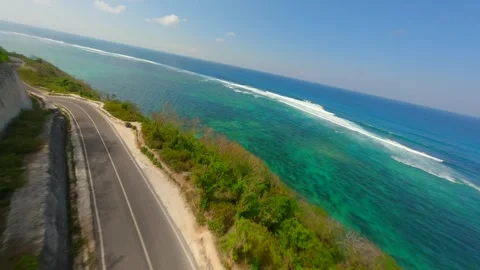 FPV flight over road in cliffs and turquoise sea of Batu Barak beach in Bali Video stock 283089299