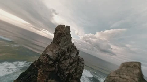 FPV flight skimming Atlantic waves before diving dramatic tall sea cliffs at Stock Footage 336203135