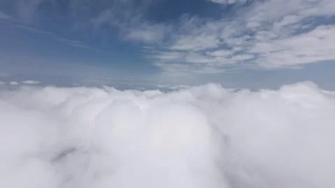 FPV flight through fluffy white clouds under a bright blue sky Stock Footage 340273008