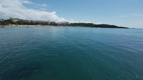 FPV Glide Over Water Transitioning to Beach Resort Coastline Stock Footage 309039108