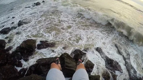 FPV: legs against the background of large waves crashing against the rocks in Stock Footage 88560465