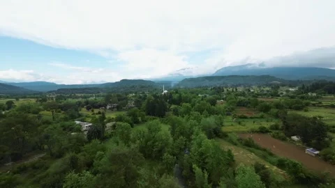 FPV Orbit of Mountain Mosque in Scenic Rural Village Stock Footage 309038837