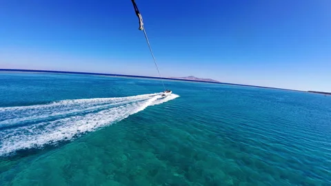 FPV parasailing over clear blue ocean speed boat wake below water sport Stock Footage 332367097