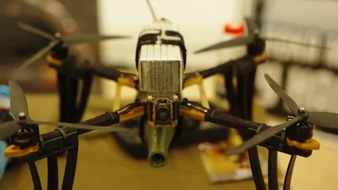 An FPV racing quadcopter drone carrying a large LiPo battery pack secured Stock Footage 339912652