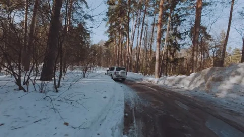 FPV shooting of a car in the forest, an SUV driving along a forest road 库存影片 330766993