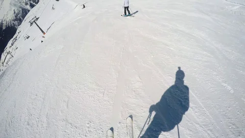 FPV Skier slopes down hill following shadow. Good weather for skiing. Action Stock Footage 109199533