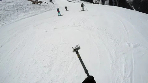 FPV snowboarder on move preparing action camera on monopod for shooting Stock Footage 139683677